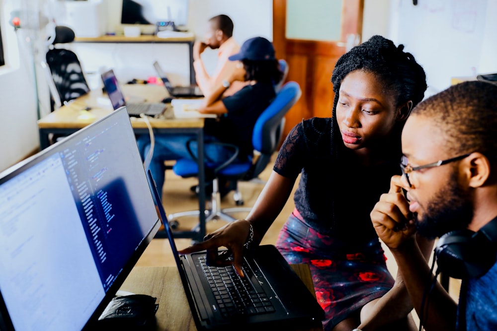 A team in a bright workshop learning AI tools on laptops
